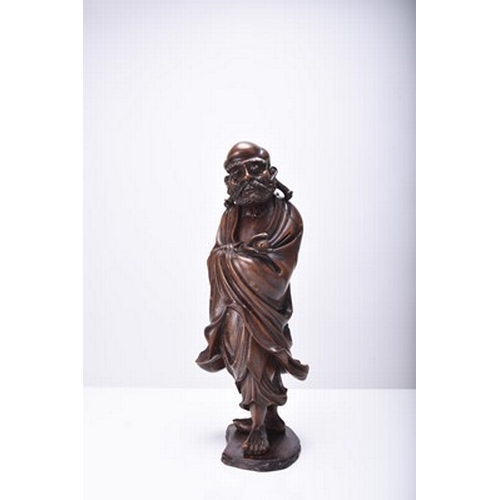 132 - Three Chinese carved wood figures of Luohan, Qing Dynasty The first modelled standing and holding a ... 