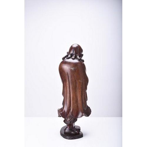 132 - Three Chinese carved wood figures of Luohan, Qing Dynasty The first modelled standing and holding a ... 