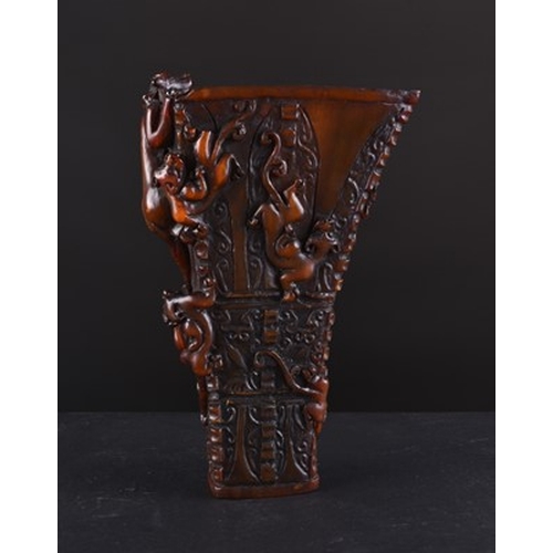 144 - A Chinese buffalo horn archaistic libation cup, Qing Dynasty Of tapering form and carved in relief w... 