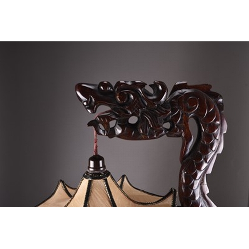 147 - A Chinese carved wood table lamp, early 20th century Modelled as a stylised dragon, with silk pendan... 