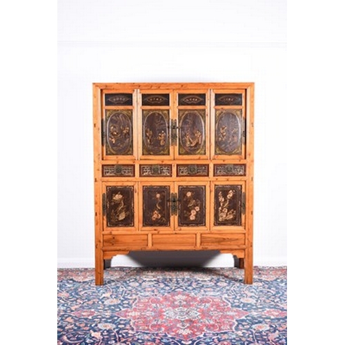 195 - A Chinese softwood and lacquer cabinet, late Qing Dynasty With a series of eight panelled doors and ... 