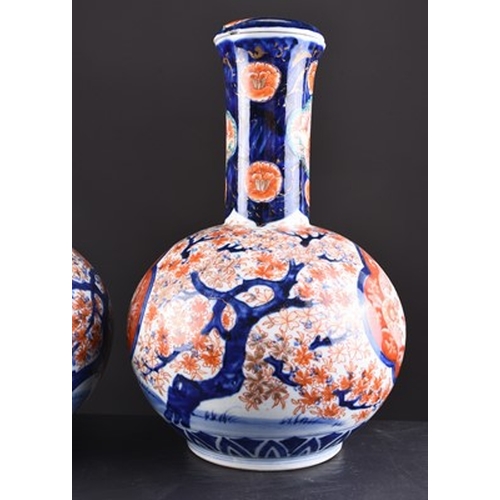 201 - A pair of Japanese Imari vases and covers, Meiji era Of bottle form and decorated with shaped panels... 