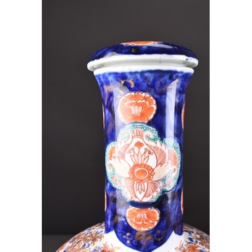 201 - A pair of Japanese Imari vases and covers, Meiji era Of bottle form and decorated with shaped panels... 