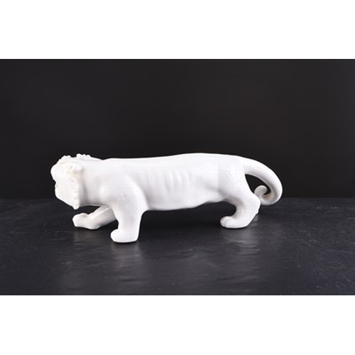 24 - A Chinese white glazed figure of a tiger, 20th century Slightly stylised form in stalking pose. 17cm... 