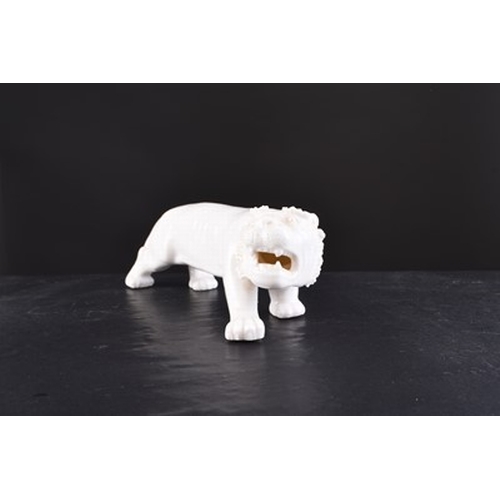 24 - A Chinese white glazed figure of a tiger, 20th century Slightly stylised form in stalking pose. 17cm... 