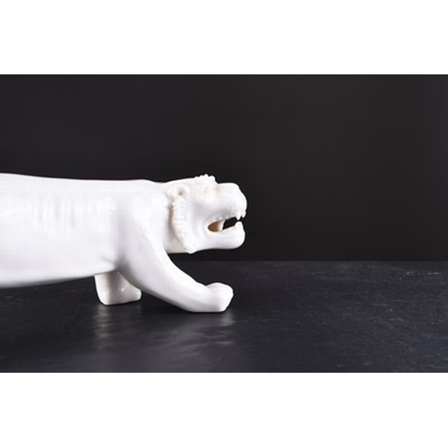 24 - A Chinese white glazed figure of a tiger, 20th century Slightly stylised form in stalking pose. 17cm... 