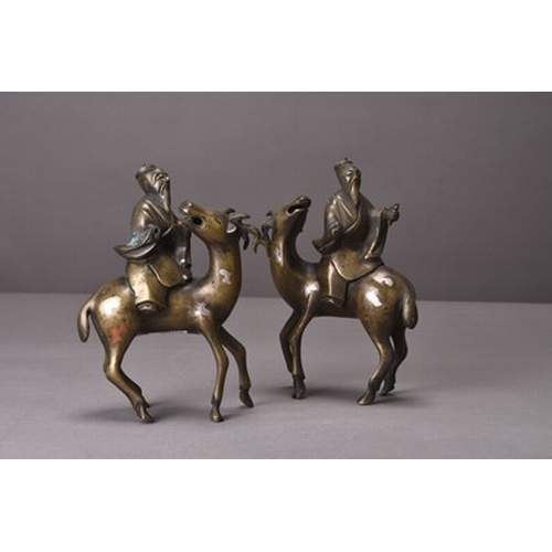 94 - Two Chinese silver-inlaid bronze figures of lohan riding deer Qing Dynasty A facing pair, the lohan ... 