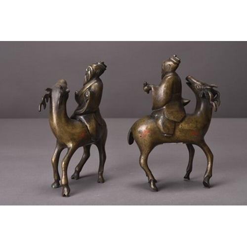 94 - Two Chinese silver-inlaid bronze figures of lohan riding deer Qing Dynasty A facing pair, the lohan ... 