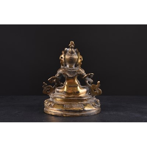 99 - A Sino-Tibetan gilt-bronze figure of Jambhala 19th century Modelled seated on a lotus base and appli... 