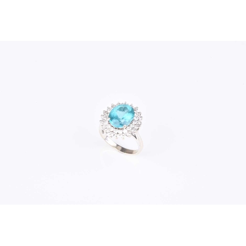 109 - A blue apatite and diamond cluster ring, designed as a central oval mixed cut blue apatite claw set ... 