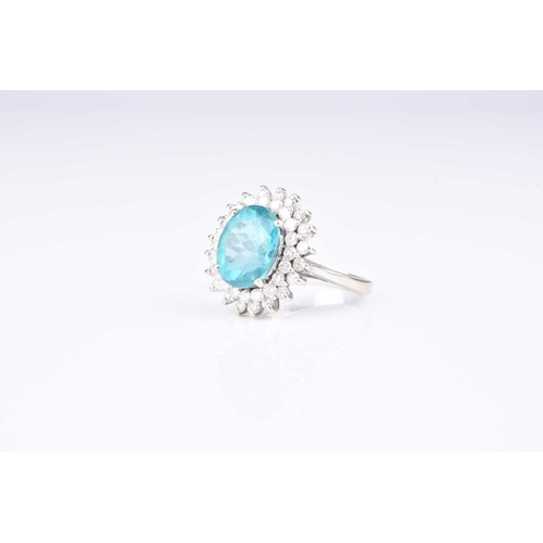 109 - A blue apatite and diamond cluster ring, designed as a central oval mixed cut blue apatite claw set ... 