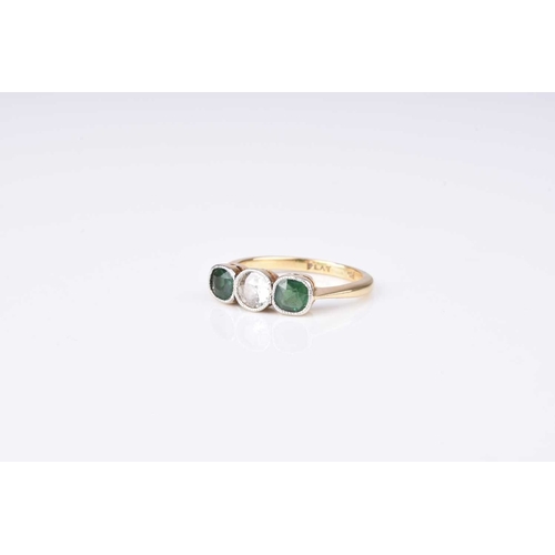 112 - A diamond and green stone ring, designed as a central old cut diamond flanked to each side by a roun... 