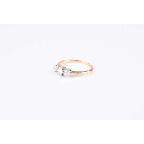 126 - A graduated three stone diamond ring, the old cut diamonds claw set in white metal to yellow metal s... 