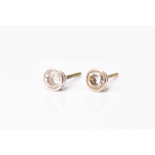 152 - A pair of diamond stud earrings, the brilliant cut diamonds collet set in white metal, total weight ... 