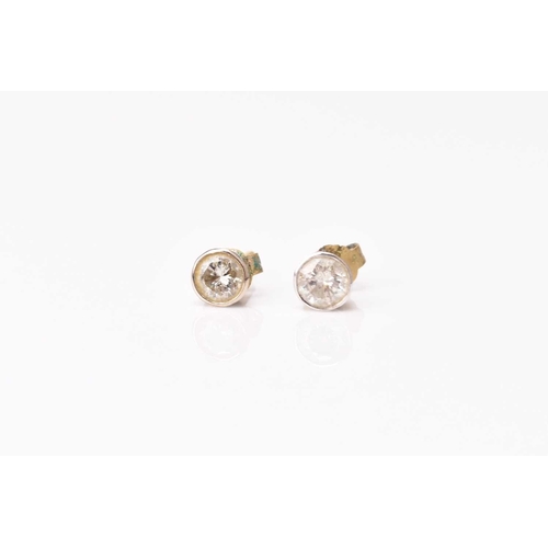 152 - A pair of diamond stud earrings, the brilliant cut diamonds collet set in white metal, total weight ... 