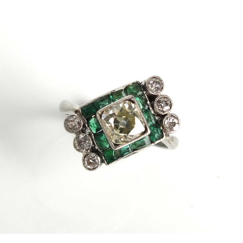 160 - An Art Deco diamond and emerald ring, designed as a central old mine cut diamond box set in white me... 