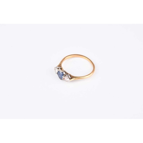 162 - A graduated three stone sapphire and diamond ring, designed as a central round mixed cut sapphire cl... 