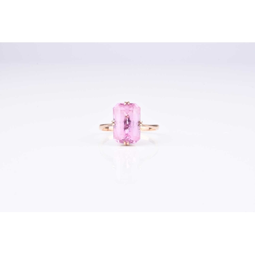 163 - A single stone synthetic pink sapphire ring, the faceted rectangular cut pink stone claw set in yell... 