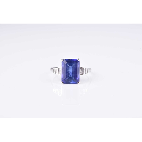 178 - A tanzanite and diamond ring, designed as a central rectangular cut tanzanite claw set in white meta... 