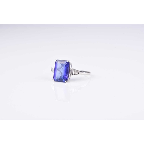 178 - A tanzanite and diamond ring, designed as a central rectangular cut tanzanite claw set in white meta... 