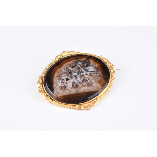 202 - A late 19th century oval hardstone brooch, within yellow metal decorative mount, 62mm wide