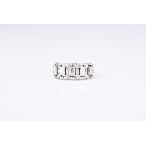 203 - A diamond dress ring, designed as five emerald cut diamonds claw set in white metal within borders o... 