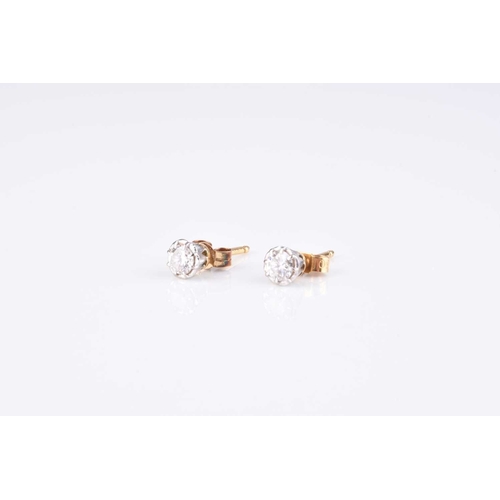 215 - A pair of diamond stud earrings, the brilliant cut diamonds claw set in white metal with yellow meta... 