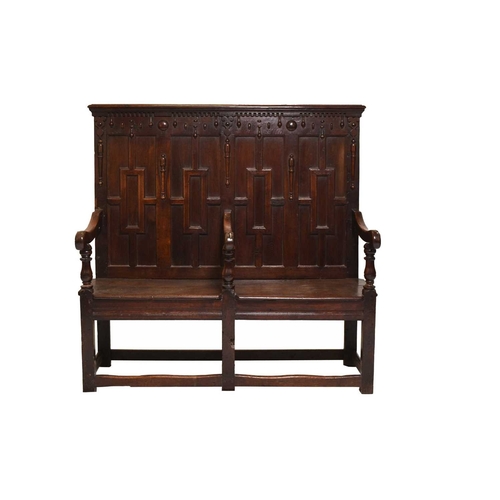 390 - An 18th century and later oak settle The back carved with geometric panels, the three scroll arms ra... 