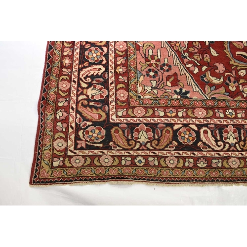 407 - A Hamadan village carpet, Iran With a central dark blue medallion on a red ground, within pink spand... 