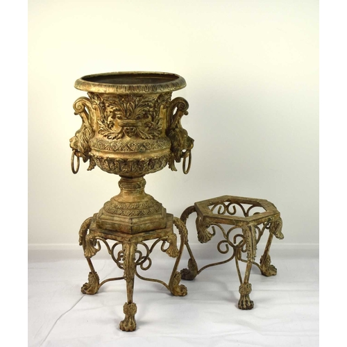 419 - A reproduction cast alloy garden urn and stand Of campana form with lion head handles and cast in re... 