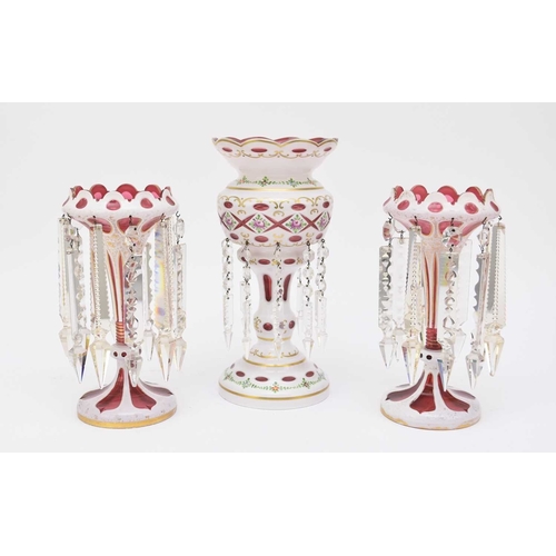 585 - An assembled garniture of three Bohemian table lustres, circa 1870-1880, cased white over ruby glass... 