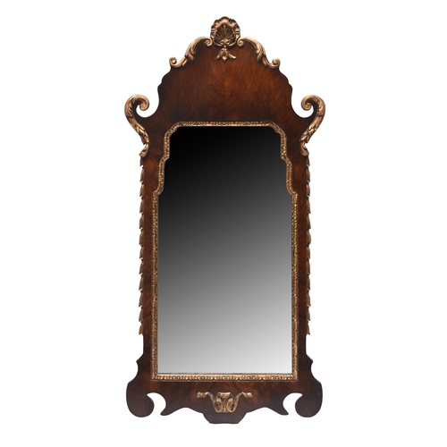 404 - A reproduction mahogany fret type wall mirror With parcel gilt shell cresting. 92cm high x 46cm wide