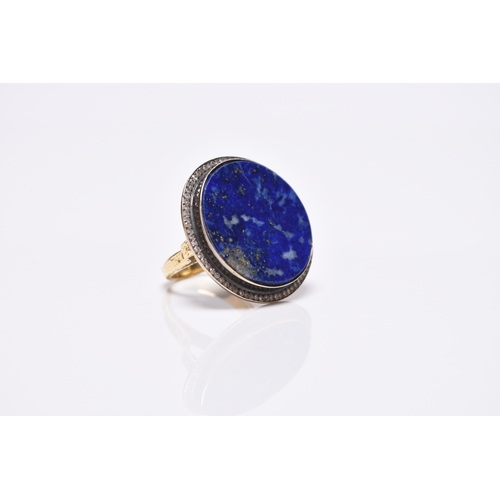 129 - An Egyptian lapis lazuli and diamond ring, designed as a circular lapis lazuli plaque collet set wit... 