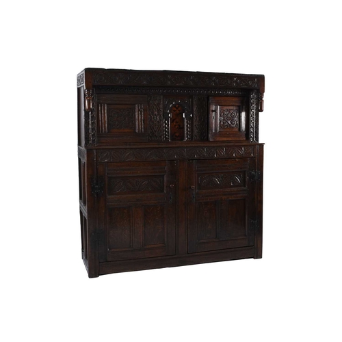 36 - A 17th century and later English oak court cupboard The top section comprising a projecting carved c... 