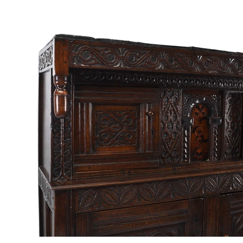 36 - A 17th century and later English oak court cupboard The top section comprising a projecting carved c... 