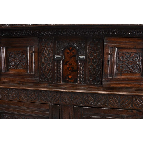 36 - A 17th century and later English oak court cupboard The top section comprising a projecting carved c... 