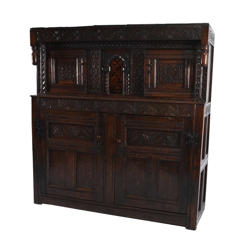 36 - A 17th century and later English oak court cupboard The top section comprising a projecting carved c... 