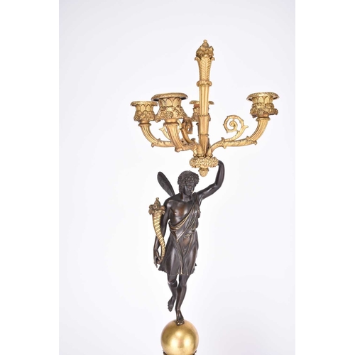 61 - A pair of French parcel gilt bronze figural candelabra Circa 1900 Each with a winged classical figur... 