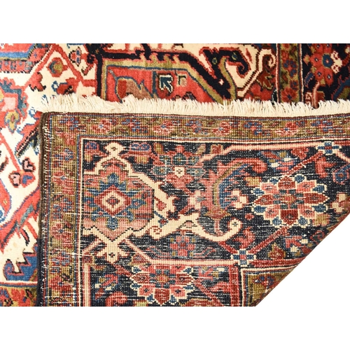 71 - A Heriz carpet, Persia Late 20th century With large geometrical and floral medallion on a red field ... 