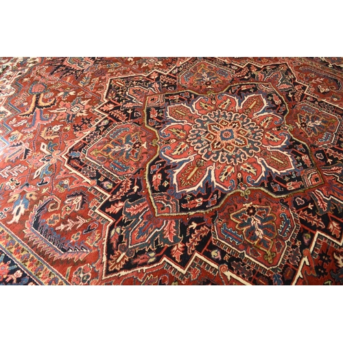 71 - A Heriz carpet, Persia Late 20th century With large geometrical and floral medallion on a red field ... 