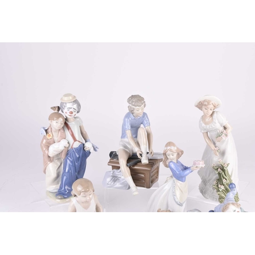 113 - A group of Nao figures and four Lladro bisque bells, including two ballerinas, two clown figures, pl... 