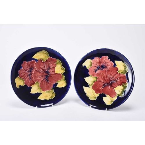 63 - A pair of limited edition Moorcroft plates in the 'Hibiscus' design, circa 1980s, tubelined with pur... 