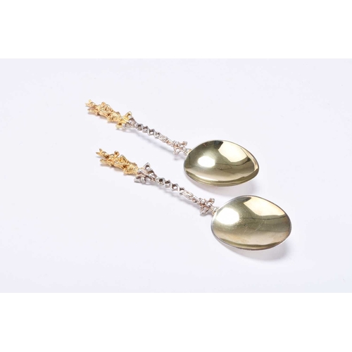 107 - A cased pair of silver and gilt spoons, John Millward Banks, Birmingham 1892, with decorative figura... 