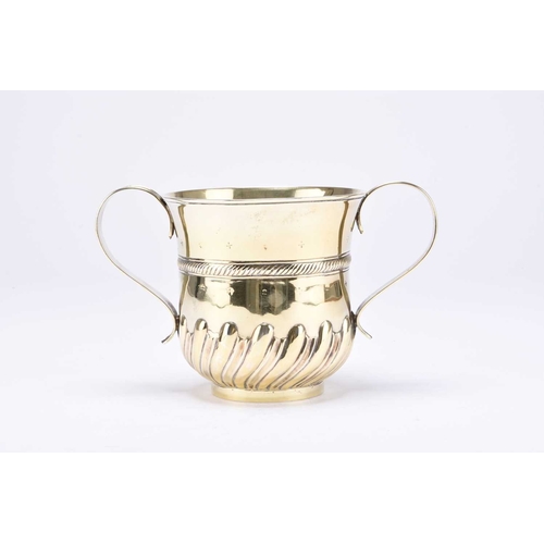 14 - A George II silver gilt porringer, Fuller White, London 1759, of typical form with embossed decorati... 