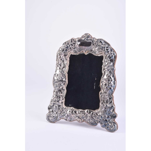 15 - An Art Nouveau silver mounted photograph frame, Birmingham 1990, of shaped rectangular form with emb... 