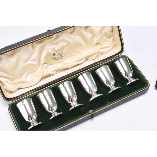 96 - An Edwardian cased set of six silver tot cups, Charles Edwards, London 1906, together with a cased s... 