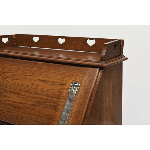 117 - An Art Nouveau style oak bureau desk, the raised back decorated with a heart shaped pierced design o... 