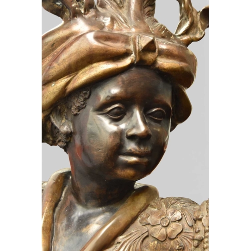 324 - A pair of reproduction bronze blackamoor torchere Modelled standing on rocky bases, wearing elaborat... 