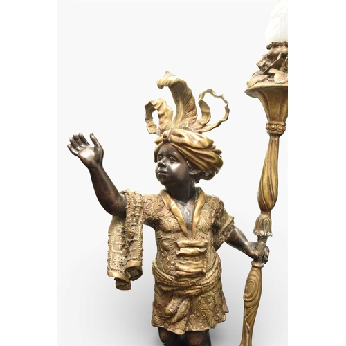 324 - A pair of reproduction bronze blackamoor torchere Modelled standing on rocky bases, wearing elaborat... 