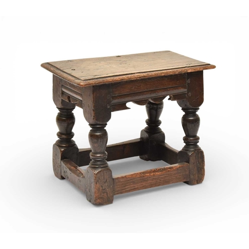 335 - A 17th century oak low joint stool The moulded seat above a channel-moulded frieze with shaped apron... 